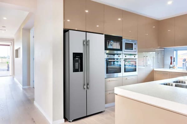 Lifestyle view of the FORNO 36-inch refrigerator with water dispenser in stainless steel, integrated into a modern kitchen setting with surrounding cabinetry and decor.