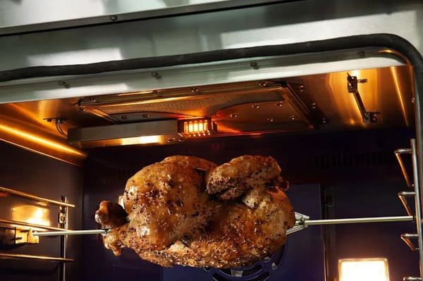 Interior view of the FORNO 48-inch gas range from the 2-Piece Appliance Package, highlighting the built-in infrared broiler element glowing red, designed for high-intensity searing, broiling, and rotisserie-style cooking with even heat distribution.
