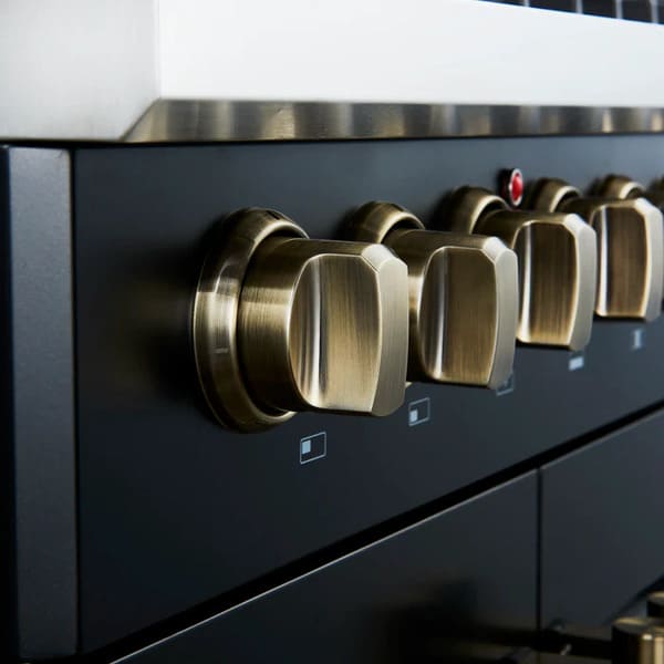Close-up of the control panel on the FORNO Galiano 30-Inch French Door Dual Fuel Range in black, featuring zinc-coated metal knobs with bezel rings and LED backlighting for a premium look and precise control.