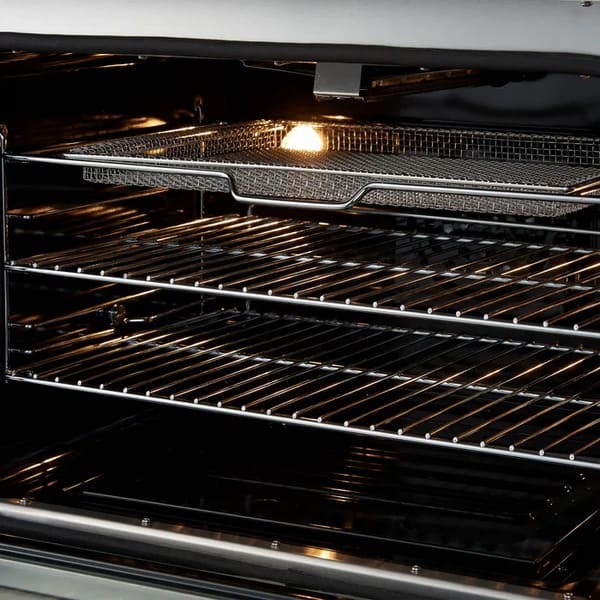 Close-up view of the air fryer basket inside the FORNO Giovanni 30-Inch Gas Range in black, highlighting its stainless steel build and blue enamel oven interior for healthier, crispy cooking.