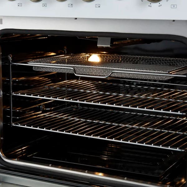 Close-up of the air fryer basket inside the FORNO Giovanni 30-Inch Gas Range in white, highlighting the stainless steel accessory set within the blue enamel convection oven interior.