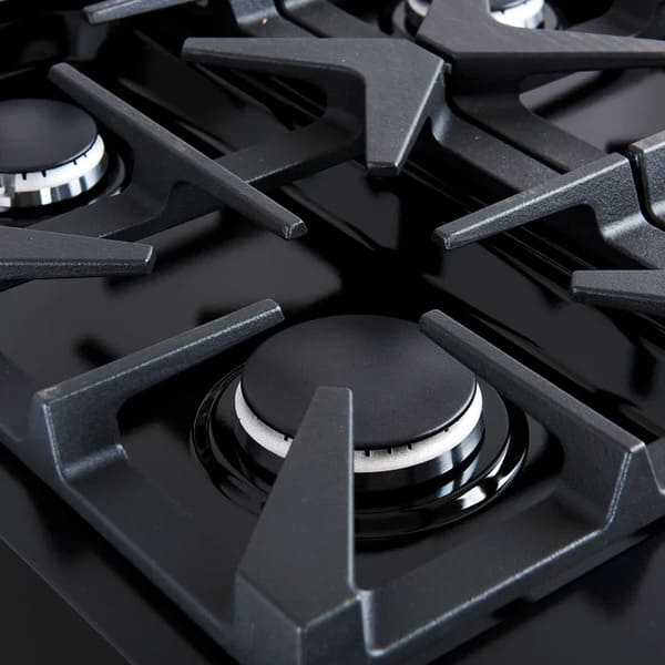 Close-up view of a brass burner on the Forno Antico 36-Inch Dual Fuel Range, highlighting premium construction, precise flame control, and heavy-duty cast iron grates.