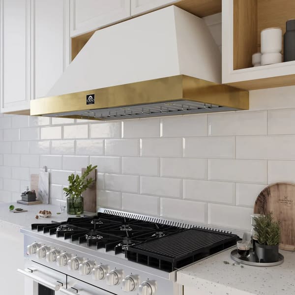 Modern kitchen setting featuring the Forno Vittorio 48-Inch Wall Mount Range Hood in white with antique brass trim, installed above a wide cooktop. The hood complements the bright cabinetry and upscale decor, blending elegance with high-performance ventilation.